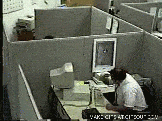 Een boze man duwt in frustratie zijn deskcomputer van het bureau af